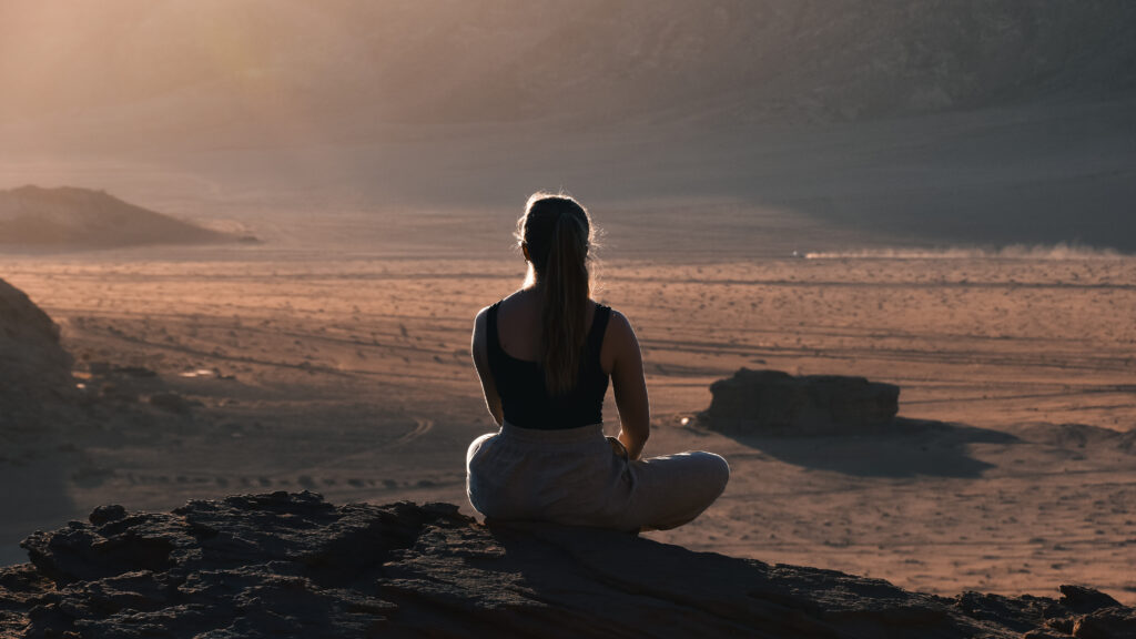 A beautiful lady watching the sunset in the desert